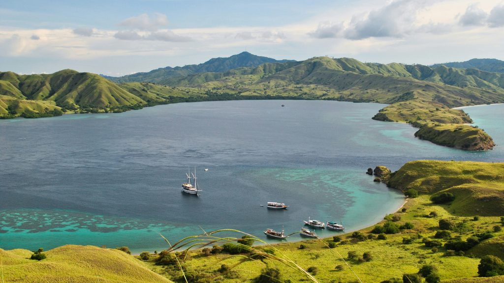 boats anchored near Gili Lawa island with surrounding hills in Komodo National Park