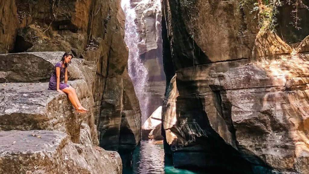 Visitor sitting near the canyon walls at Cunca Wulang Waterfall Flores Indonesia