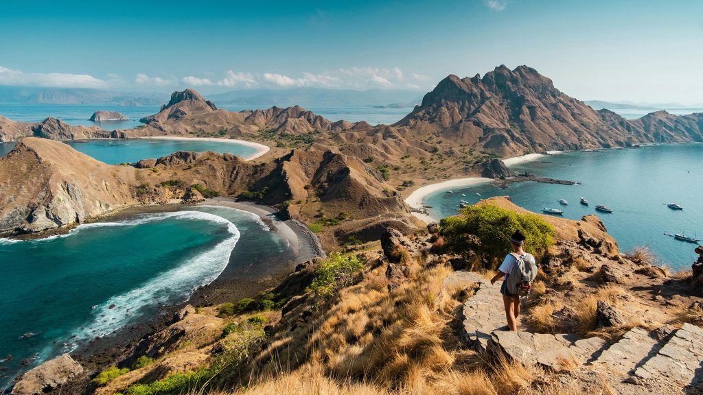 hiker walking along padar island trail with panoramic views of the three bays