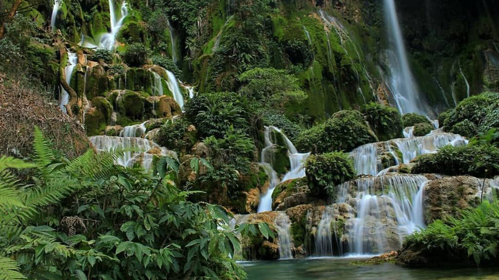 kanabu wai waterfall surrounded by lush tropical forest