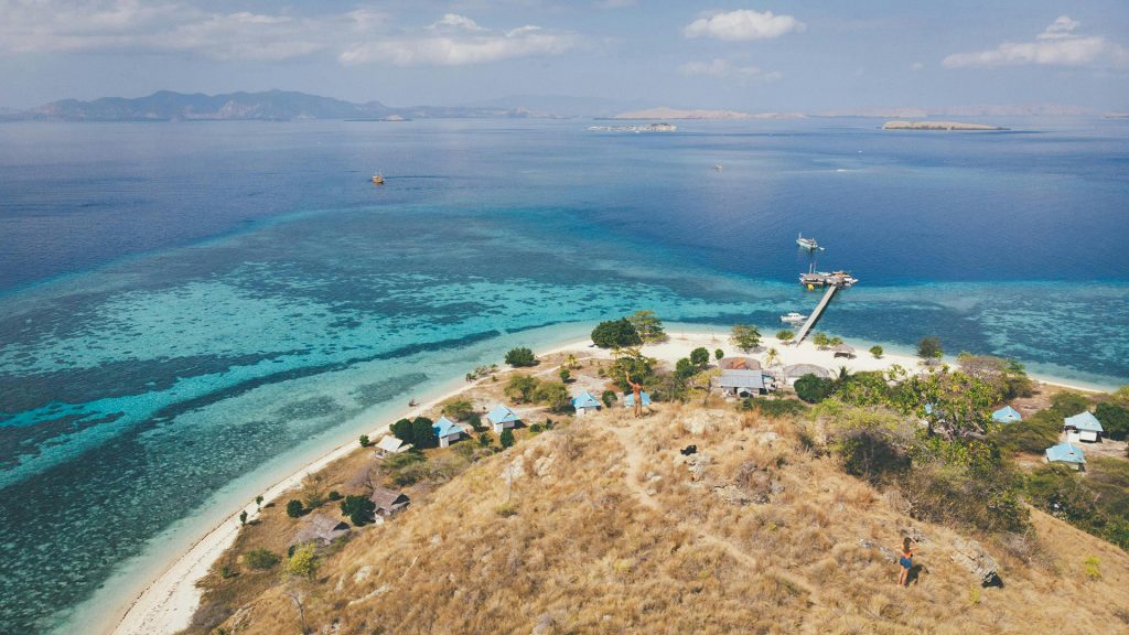 Hilltop view showing coral reefs, beach, and clear turquoise sea in Flores