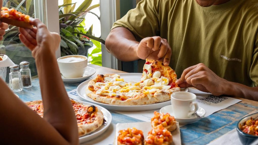 people enjoying pizza at la cucina italian restaurant labuan bajo