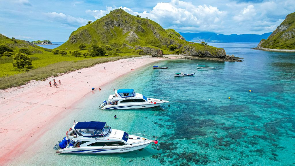 speedboat anchored at tropical island during labuan bajo island hopping tour