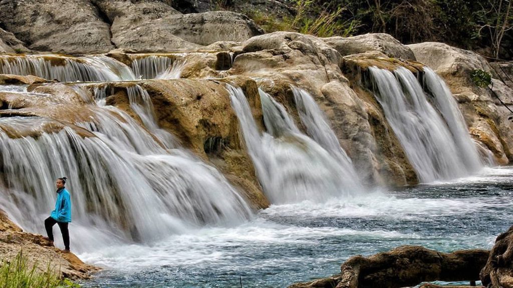 clear waterfall cascading over rocks at lakolat waterfall
