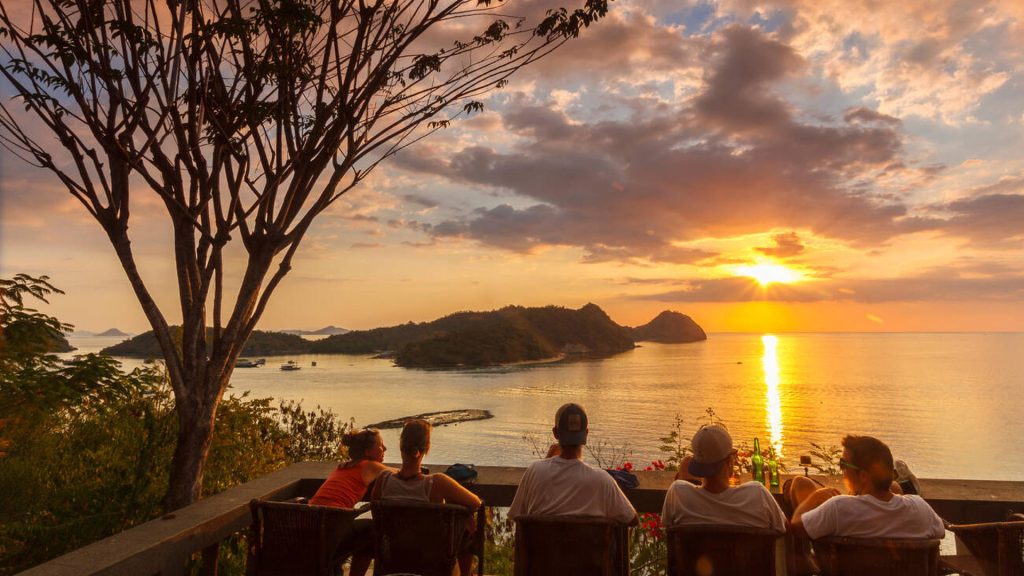 people relaxing at paradise bar watching sunset in labuan bajo