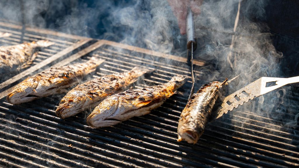fresh grilled fish being cooked on a barbecue grill