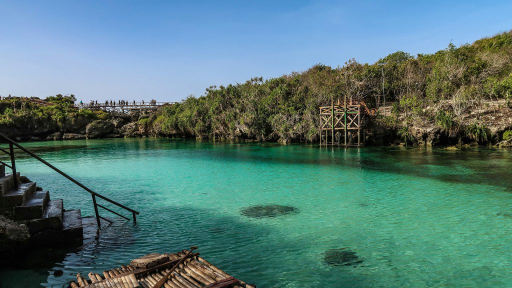 turquoise natural lagoon surrounded by rocks at weekuri lagoon